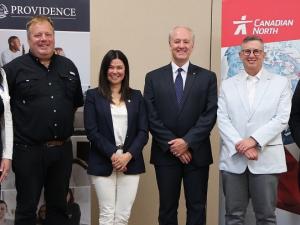 Representatives from Providence University College, Harv’s Air Service, and Canadian North Airlines gather to witness the signing of their new partnership agreement.