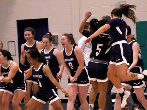 The women's basketball team celebrates a hard-fought victory.