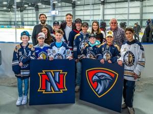 Nighthawks board members Jeremy Braun, Ray Dowse, and Clarence Braun show off the new logo with local hockey and ringette players.