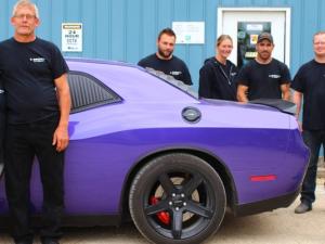 Carol Brown with her husband Brian and autobody staff.