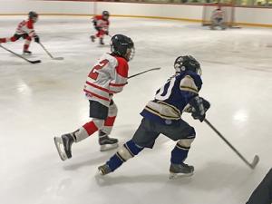 Players fight for the puck at the Niverville Arena