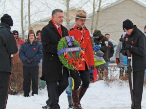 MP Ted Falk lays a wreath at a Remembrance Day ceremony in Lorette