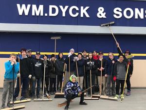 The Rush, sweeping and cleaning the Wm Dyck & Sons parking lot in exchange for a donation