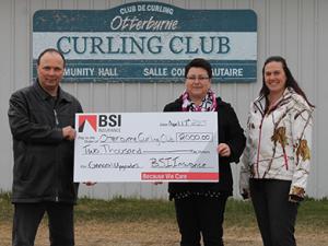 Sharon Martel and Reane Philippot from St. Pierre BSI present a cheque to Albert Poirier, Curling Club Director