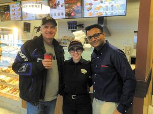 Ken Krahn receives the first cup of coffee at Niverville's new Tim's