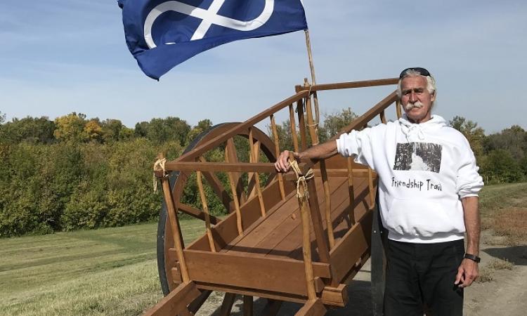 Gerry Lagasse alongside a Red River cart at the Friendship Trail in St. Adolphe.
