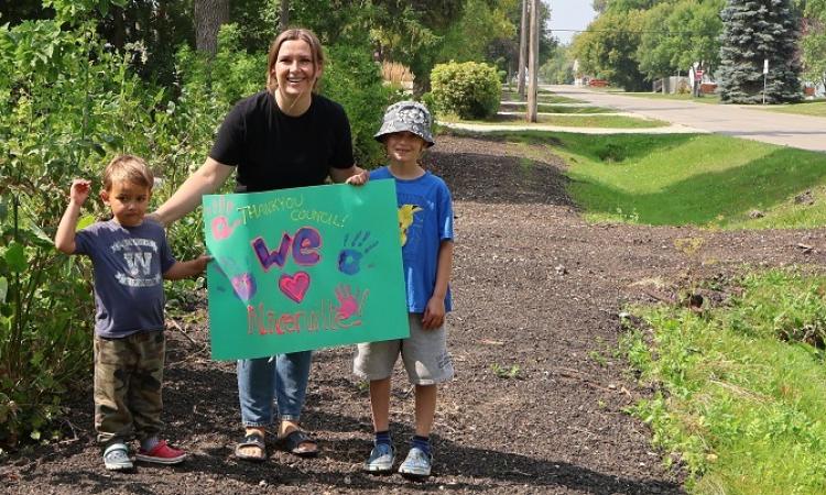 Crystal Isaak and her two children after the sidewalk along First Street South was removed this summer.