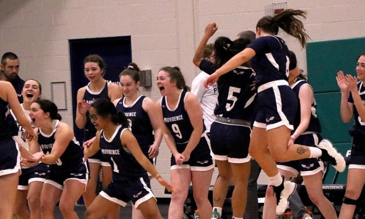 The women's basketball team celebrates a hard-fought victory.