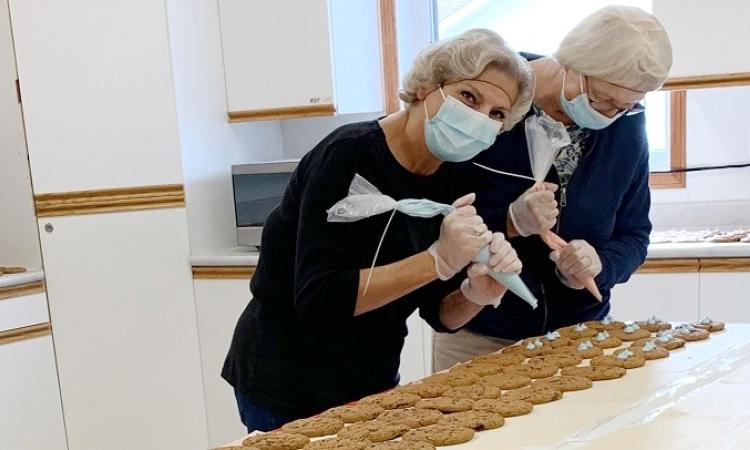 Volunteers Evelyn Mcfarlane and Jeanette Fast decorate Smile Cookies at the Golden Friendship Centre.