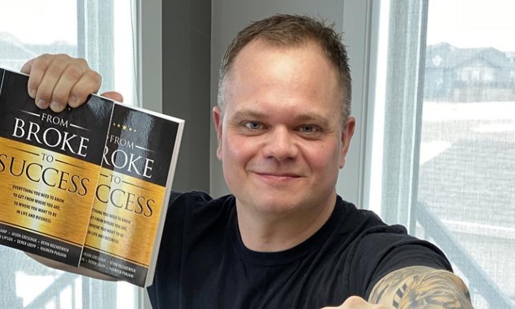 Derek Loepp with copies of the book he contributed to.