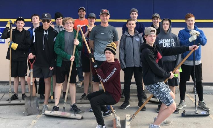 Rush players build some sweat equity by sweeping the Wm. Dyck & Sons parking lot in exchange for a generous donation