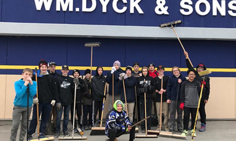 The Rush, sweeping and cleaning the Wm Dyck & Sons parking lot in exchange for a donation