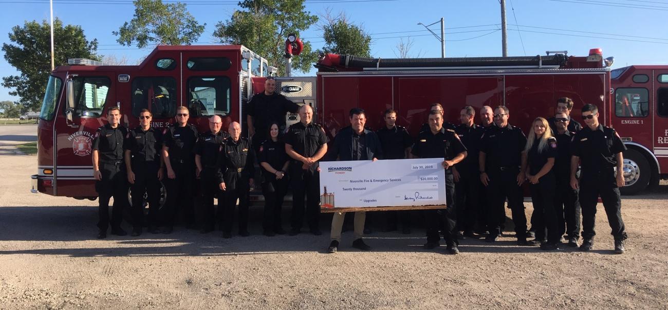 Greg Knox of Richardson International presents a donation cheque to Fire Chief Keith Bueckert.