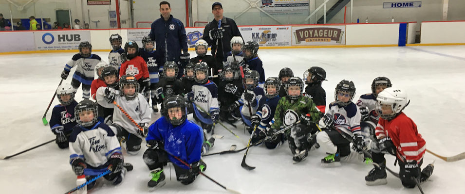 The Initiation Blue and White teams alongside Winnipeg Jets coaches Todd Woodcroft and Troy Stevens.