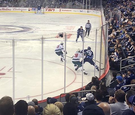 Players jockey for the puck at Bell MTS Place