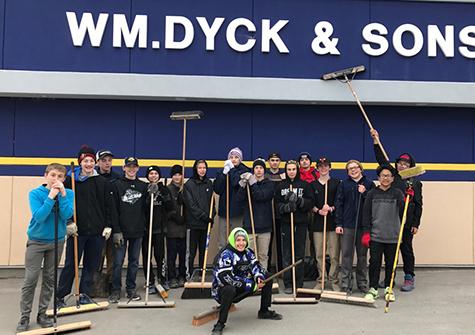 The Rush, sweeping and cleaning the Wm Dyck & Sons parking lot in exchange for a donation