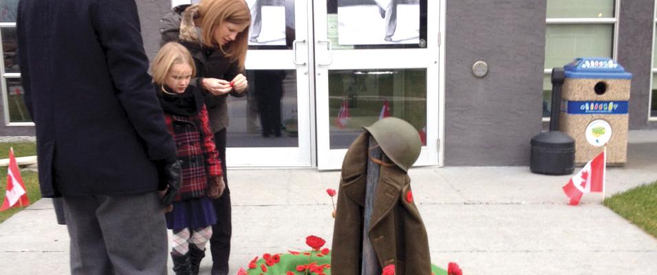 Attendees at Niverville's 2015 Remembrance Day service laying their poppies
