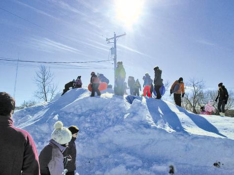 Kids climb the toboggan hill at Niverville's Family Fun Day