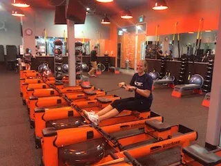 Chantel smiling through the pain on the rowing machines at Orange Theory