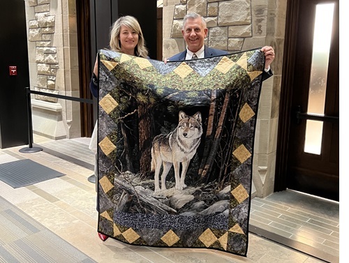 Melanie Joly and Ted Falk hold the Zelensky quilt at the House of Commons in Ottawa.