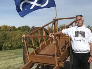 Gerry Lagasse alongside a Red River cart at the Friendship Trail in St. Adolphe.