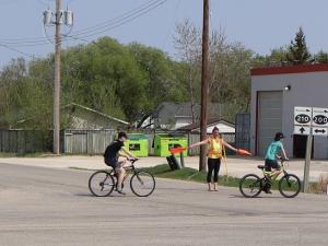 A crossing guard directs children through the intersection of Highways 200 and 201 in St. Adolphe.
