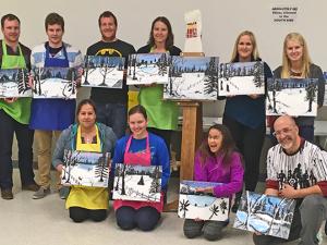 Paint night participants who off their art.