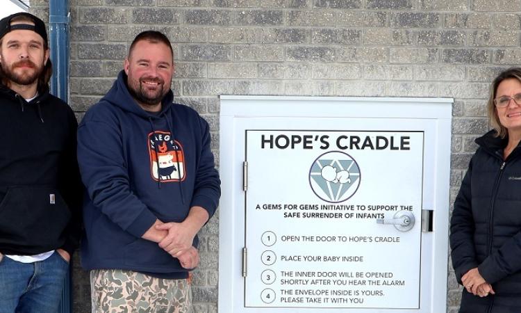 Hope’s Cradle installers Zack Ronaldson and Allan Ward alongside Susan Penner, executive director of Life Culture.