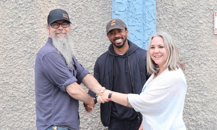Entrepreneurs Tyree Milton-Gordon and Becky Nielsen shake hands with Troy Waldner, owner of 61 Main Street, which will be the site of their new rage room.