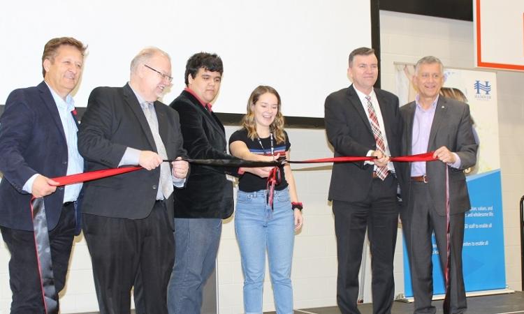 The ribbon-cutting ceremony, with MLA Ron Schuler, Minister of Education Kelvin Goertzen, students Dominic Augusto and Katey Hiebert, Mayor Myron Dyck, and MP Ted Falk.