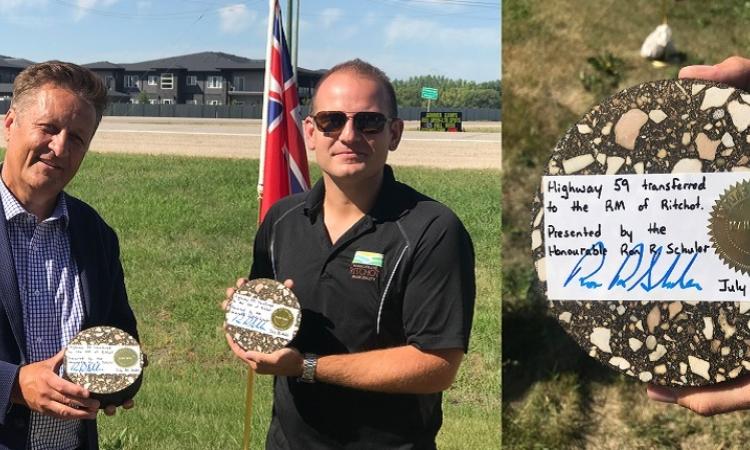 MLA Ron Schuler and Ritchot Mayor Chris Ewen, displaying transfer of ownership keepsakes made from the road's asphalt surface.