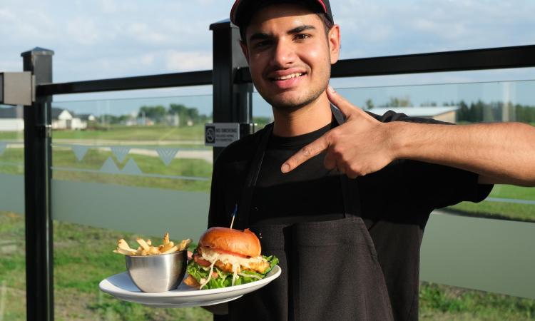 Harkirat Khattra with his signature Maharaja Chicken burger at Smitty's Niverville.