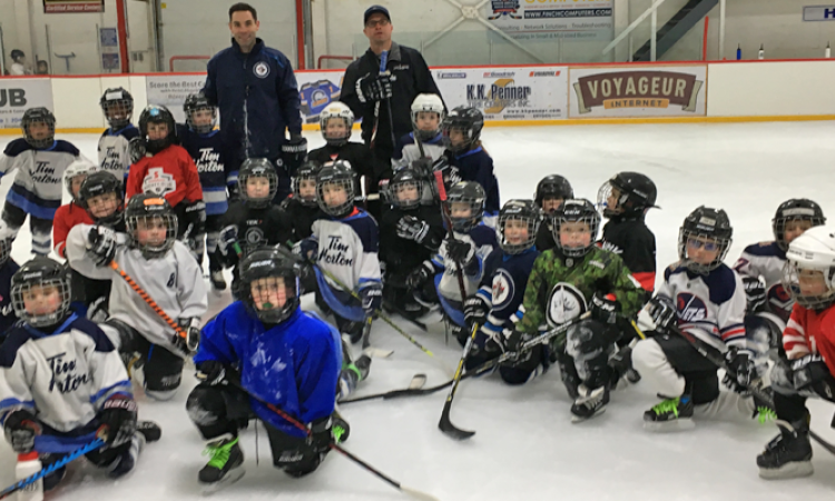 The Initiation Blue and White teams alongside Winnipeg Jets coaches Todd Woodcroft and Troy Stevens.
