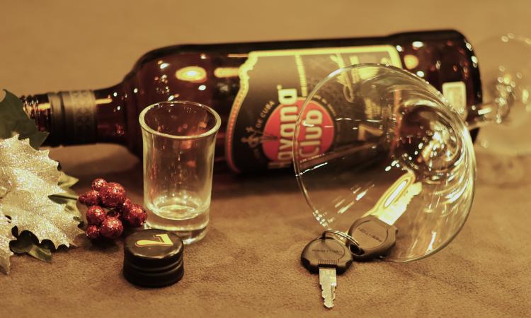 Car keys next to empty alcohol bottle.