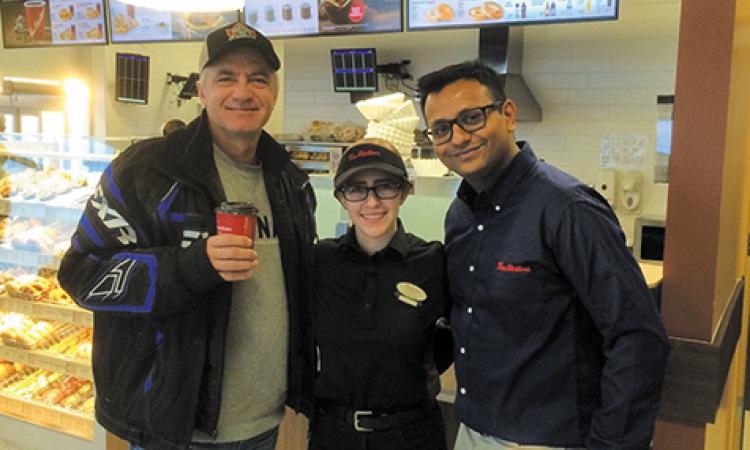 Ken Krahn receives the first cup of coffee at Niverville's new Tim's
