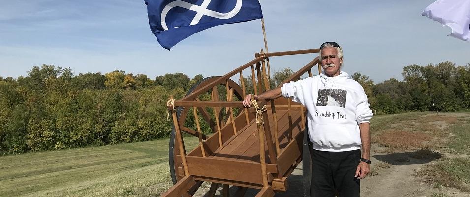 Gerry Lagasse alongside a Red River cart at the Friendship Trail in St. Adolphe.