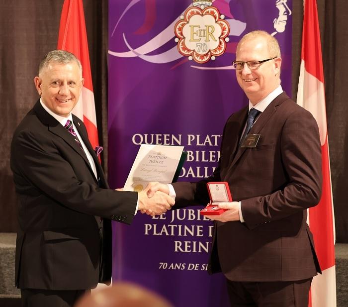 Darryl Rempel of Niverville receives his Queen Elizabeth II Platinum Jubilee medal from MP Ted Falk.