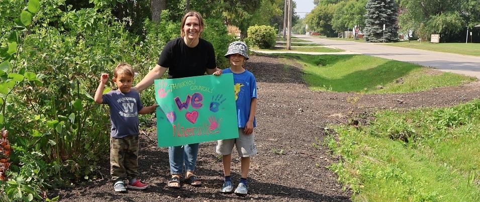 Crystal Isaak and her two children after the sidewalk along First Street South was removed this summer.