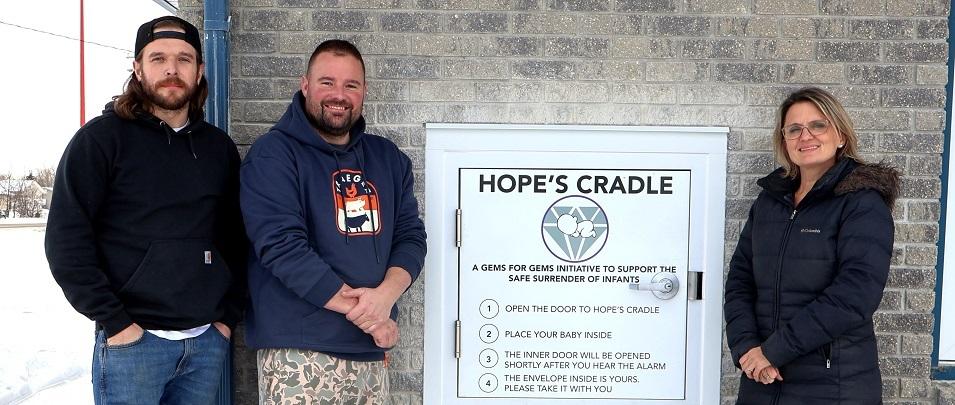 Hope’s Cradle installers Zack Ronaldson and Allan Ward alongside Susan Penner, executive director of Life Culture.