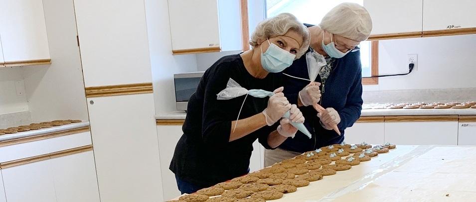 Volunteers Evelyn Mcfarlane and Jeanette Fast decorate Smile Cookies at the Golden Friendship Centre.