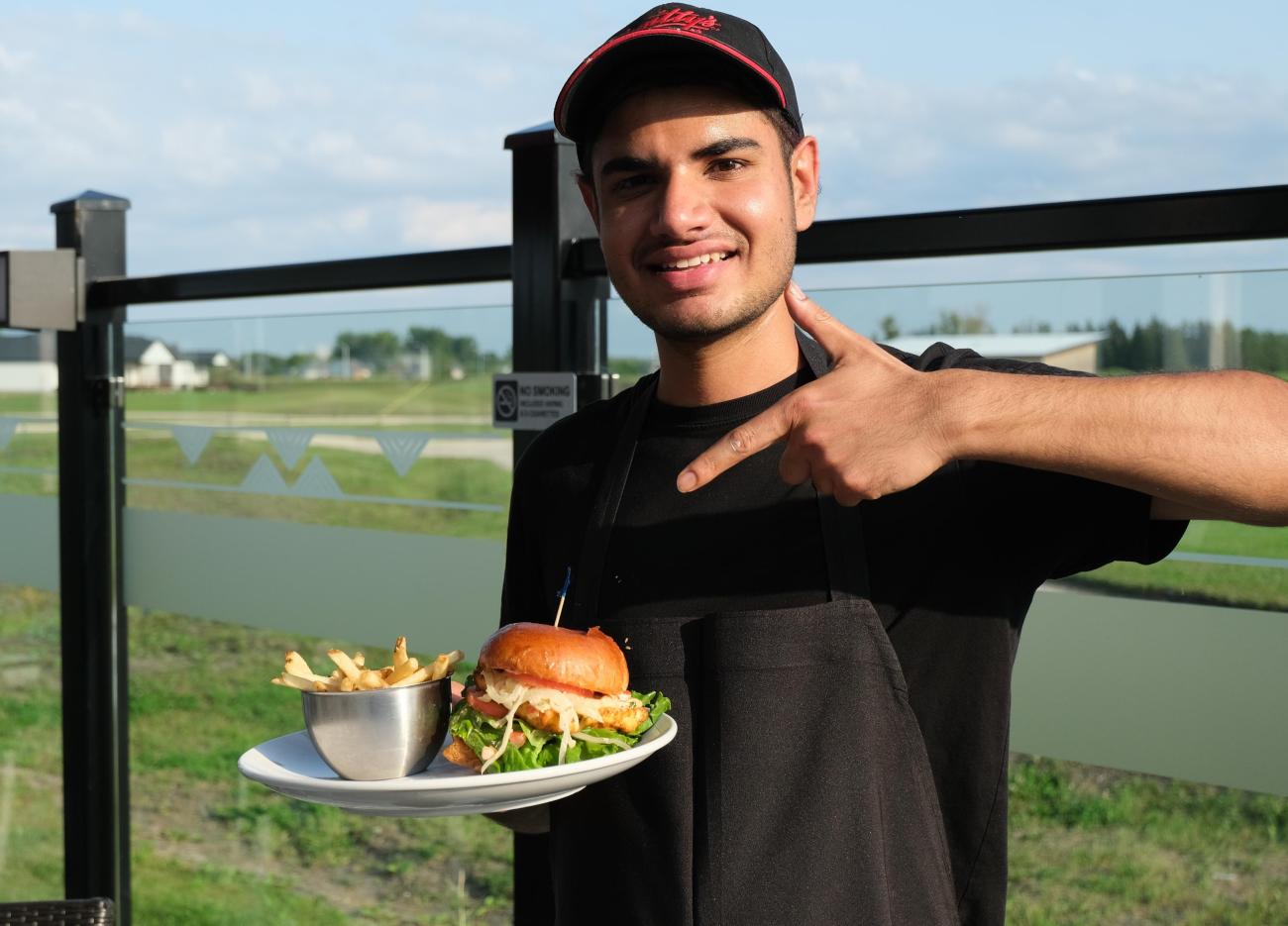 Harkirat Khattra with his signature Maharaja Chicken burger at Smitty's Niverville.