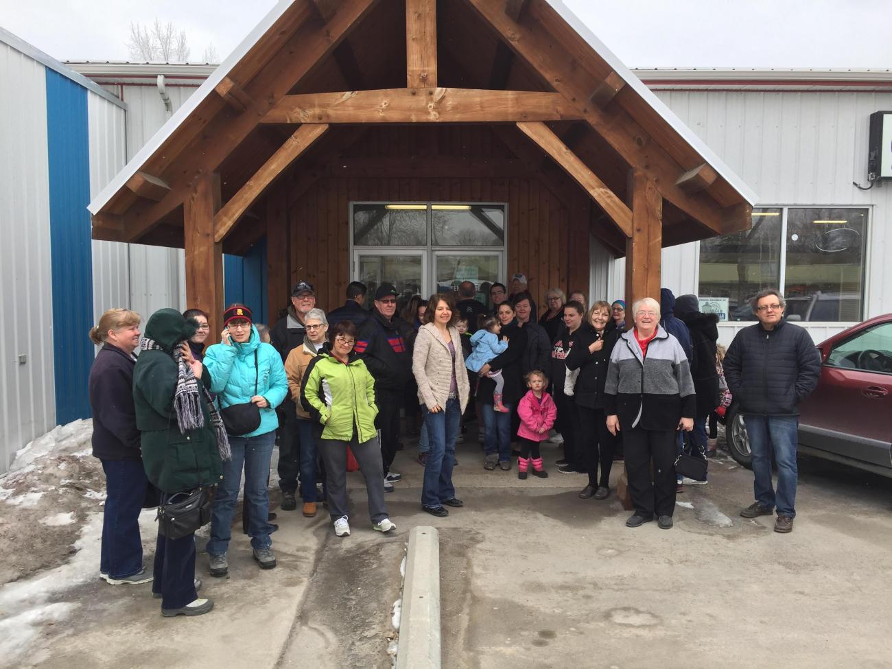 A crowd of eager shoppers gathers outside the thrift store on a chilly Tuesday morning.