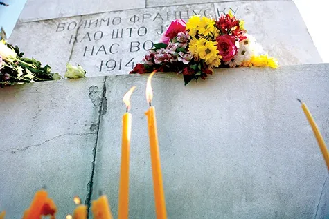 People in Belgrade lay flowers and light candles in front of Monument of Friendship with France and Serbia